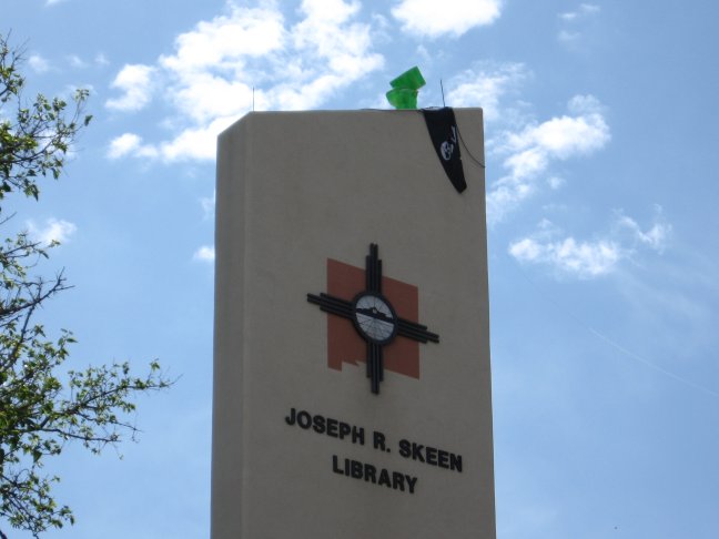 Photo of a lime-green toilet perched atop the clock tower of Skeen Library.